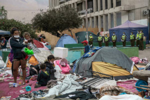 Migrantes recogen sus pertenncias al ser evacuados de la plaza Brasil de la ciudad de Iquique, en Chile, el 24 de septiembre de 2021 MARTIN BERNETTI AFP