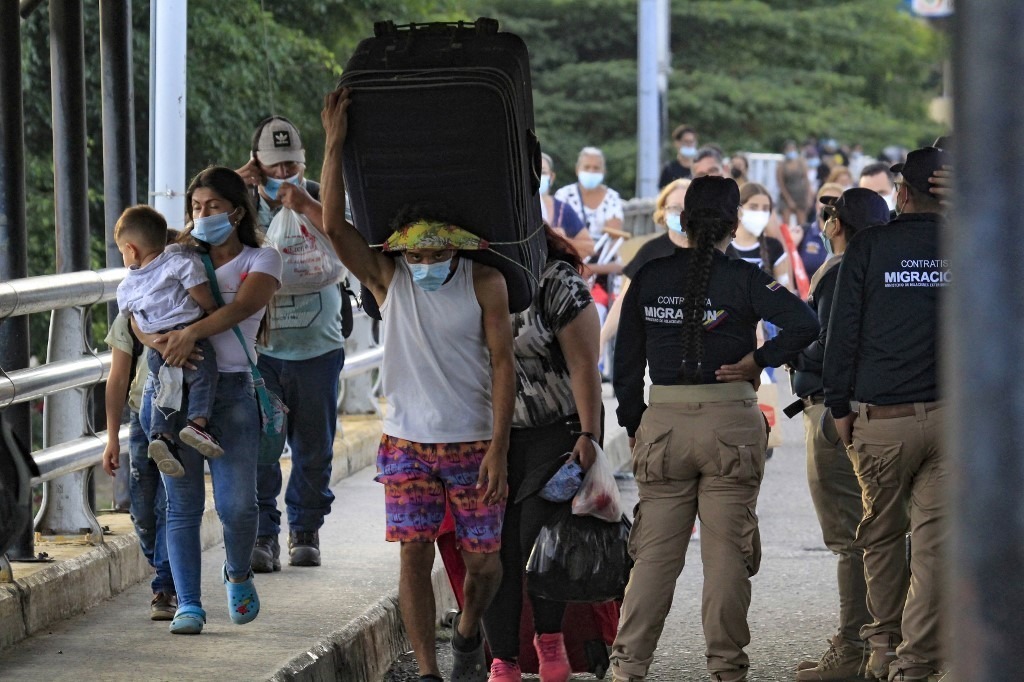 Migrantes en paso fronterizo. Foto: AFP