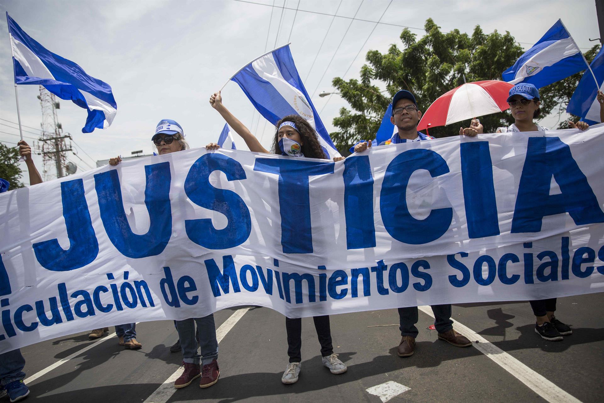 AME3367. MANAGUA (NICARAGUA), 14/03/2022.- Fotografía de archivo del 21 de julio de 2018 que muestra a varios manifestantes que sostienen una pancarta en demanda de justicia durante una protesta en contra del gobierno de Daniel Ortega, en Managua (Nicaragua). Organizaciones humanitarias solicitaron este lunes a la Comisión Interamericana de Derechos Humanos (CIDH) que adopte "medidas extraordinarias" que garanticen la rendición de cuentas por las muertes ocurridas en Nicaragua desde 2018, cuando estalló una revuelta popular calificada como un intento de golpe de Estado por el Gobierno de Daniel Ortega. EFE/ Jorge Torres ARCHIVO