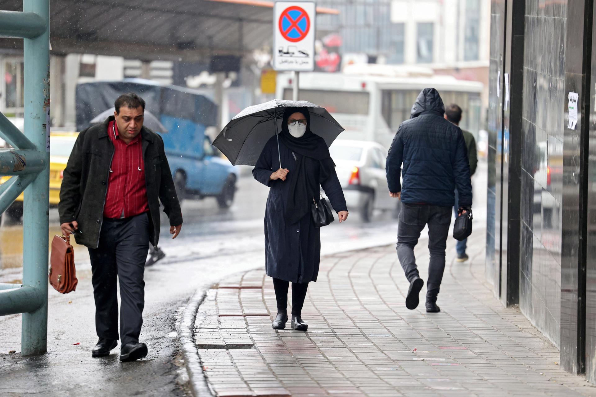 Teherán (República Islámica de Irán), 04/12/2022.- Una mujer camina por una calle en un día lluvioso en Teherán, Irán, 04 de diciembre de 2022. (Protestas, Teherán) EFE/EPA/STRINGER.