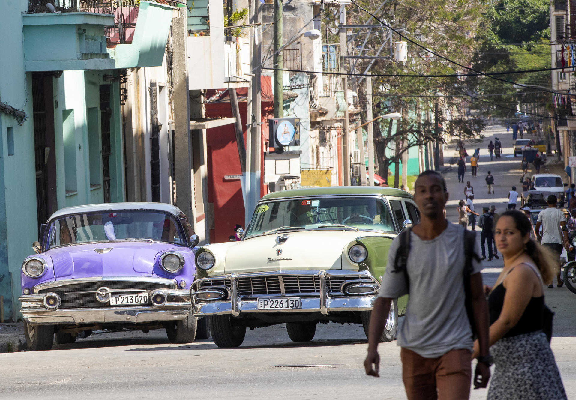 FOTO REFERENCIAL- LA HABANA (CUBA), 07/02/2023.- Un grupo de personas camina por las calles junto a dos vehículos clásicos, emblemáticos de la isla cubana, este martes en La Habana. EFE/ Yander Zamora.