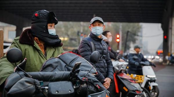 Ciudadanos en Beijing obligados a utilizar mascarilla por una ola de smog reciente. Foto: EFE.