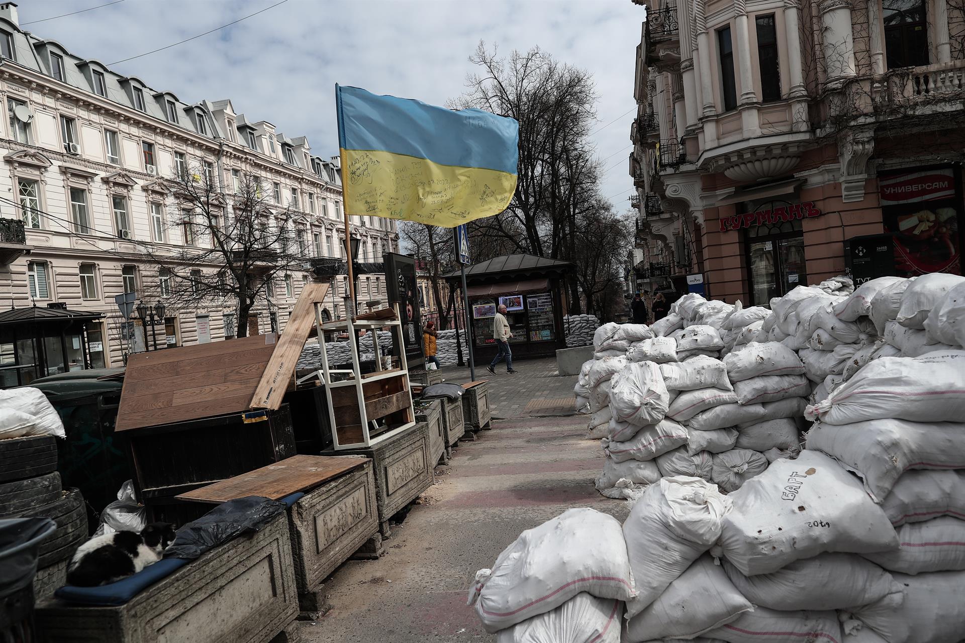Odessa (Ucrania), 21/03/2022.- Los ucranianos caminan junto a una barricada en la ciudad de Odesa, en el sur de Ucrania, el 21 de marzo de 2022. Las tropas rusas entraron en Ucrania el 24 de febrero, lo que llevó al presidente del país a declarar la ley marcial y desencadenó una serie de anuncios por parte de los países occidentales de imponer severas sanciones económicas a Rusia. (Rusia, Ucrania) EFE/EPA/SEDAT SUNA