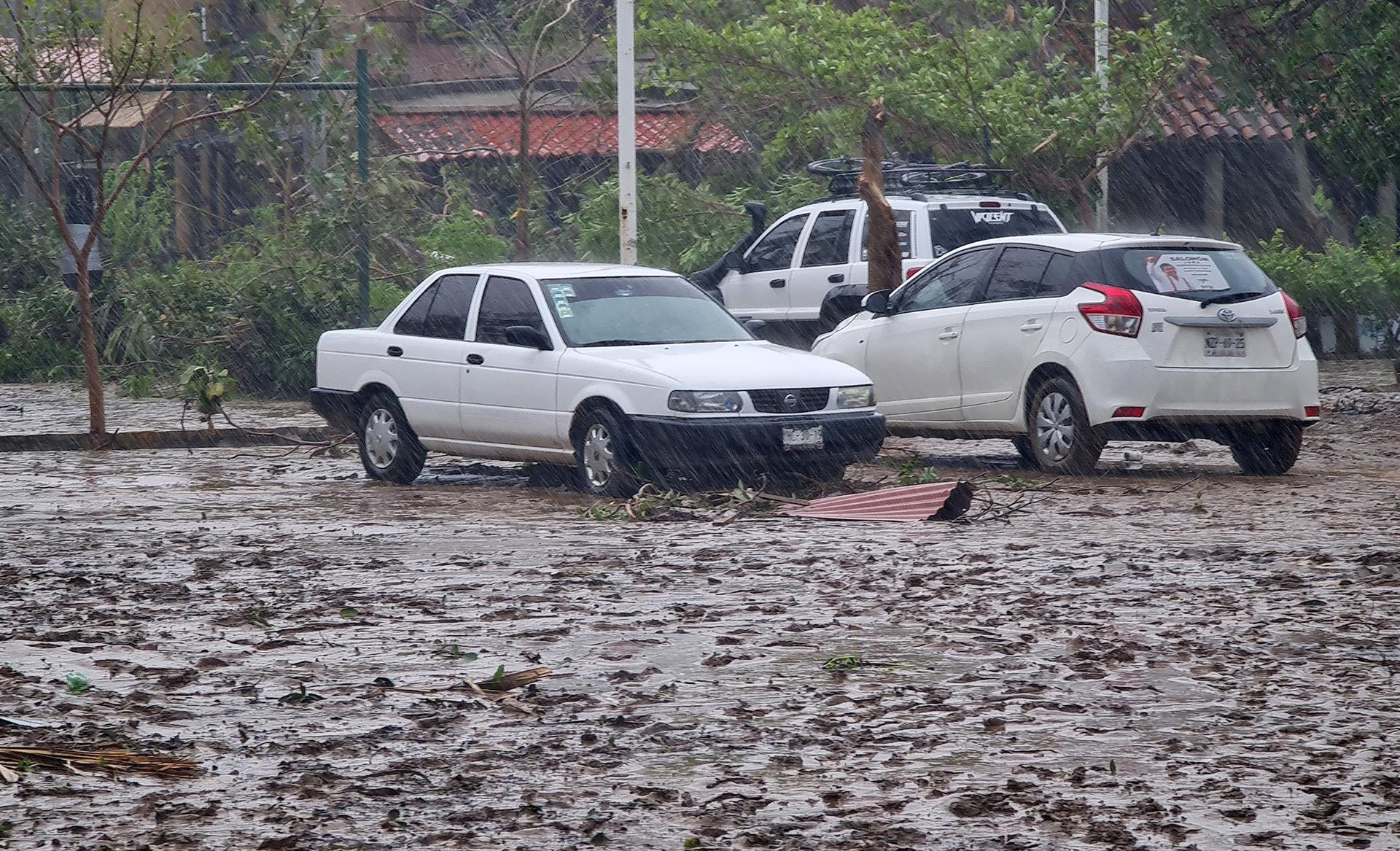 MEX5193. MAZUNTE (MÉXICO), 31/05/2022.- Vista de vehículos durante una intensa lluvia debido a las afectaciones por el paso del ciclón Agatha, hoy en la comunidad de Mazunte, en el estado de Oaxaca (México). El inicio de la temporada de huracanes dejó este martes al menos cuatro muertos y cuatro desaparecidos en territorio mexicano tras el embate del ciclón Agatha, que antes de debilitarse dejó daños en el sureño estado de Oaxaca, una de las zonas más pobres del país. EFE/Daniel Ricardez