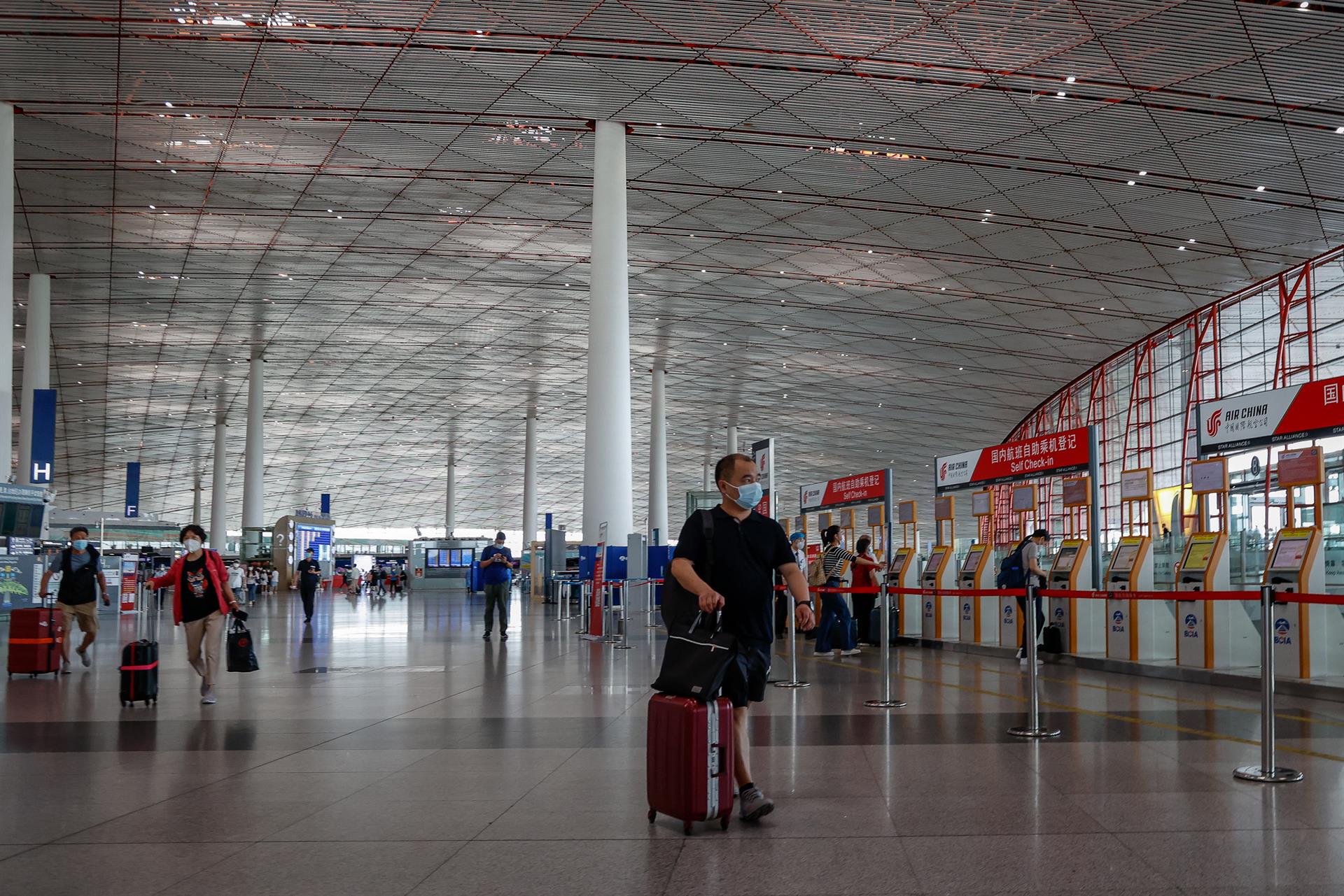 -FOTODELDÍA- PEKÍN, 29/06/2022.- Varias personas caminan por el Aeropuerto Internacional de Pekín, en China, este miércoles. China ha reducido el periodo de cuarentena de las llegadas del extranjero con la permanencia de siete días en un centro gestionado por el gobierno y tres días en arresto domiciliario. EFE/Mark R. Cristino