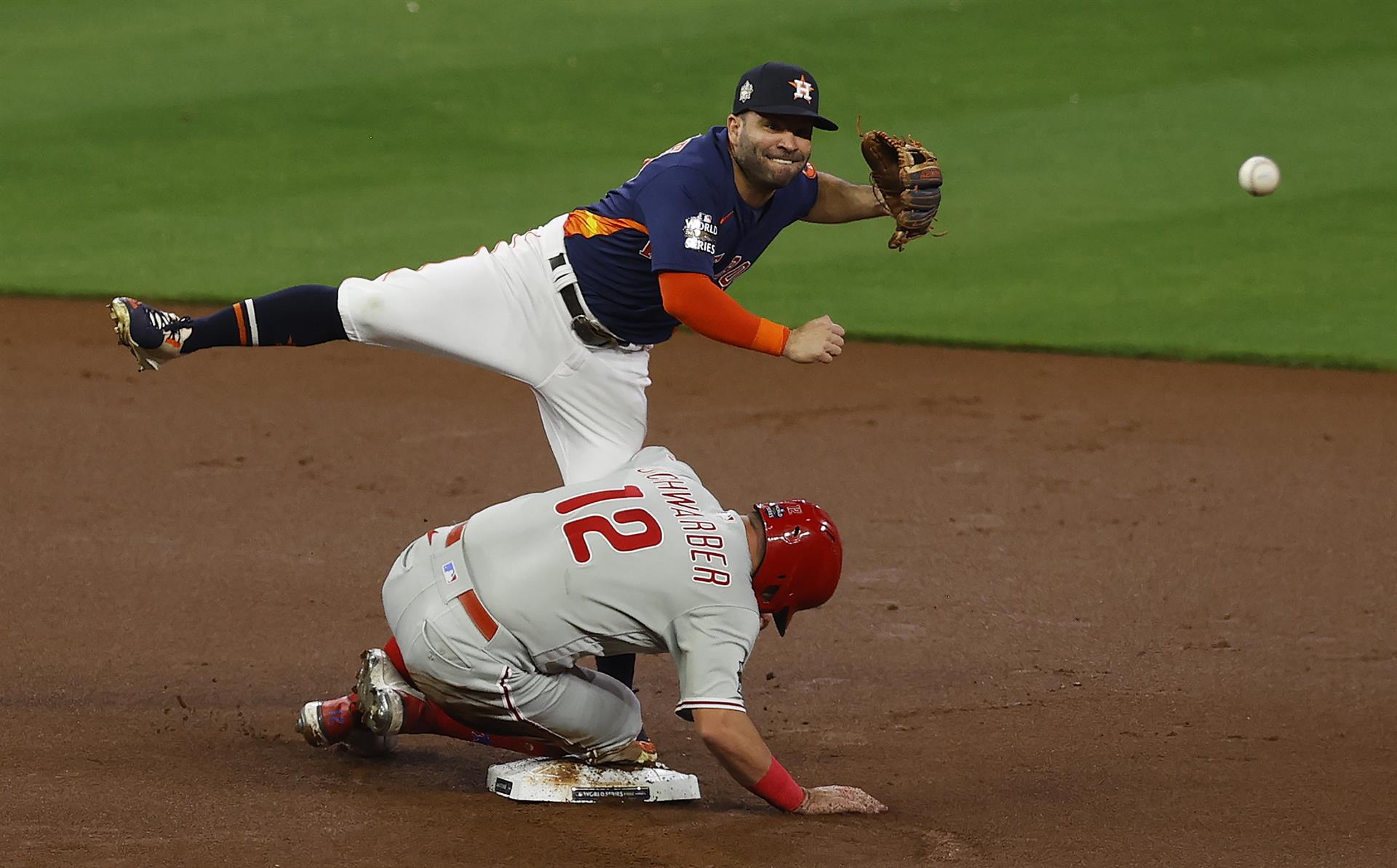 Houston (Estados Unidos), 05/11/2022.- El segunda base de los Astros de Houston, José Altuve (T), hace un relevo hacia la primera base después de forzar el out del corredor de base de los Filis de Filadelfia, Kyle Schwarber (B), para completar una doble jugada en una bola bateada por el bateador Rhys Hoskins, en la parte alta de la primera entrada del sexto juego de la Serie Mundial en el Minute Maid Park en Houston, Texas, Estados Unidos, 05 de noviembre de 2022. (Estados Unidos, Filadelfia) EFE/EPA/AARON M. SPRECHER